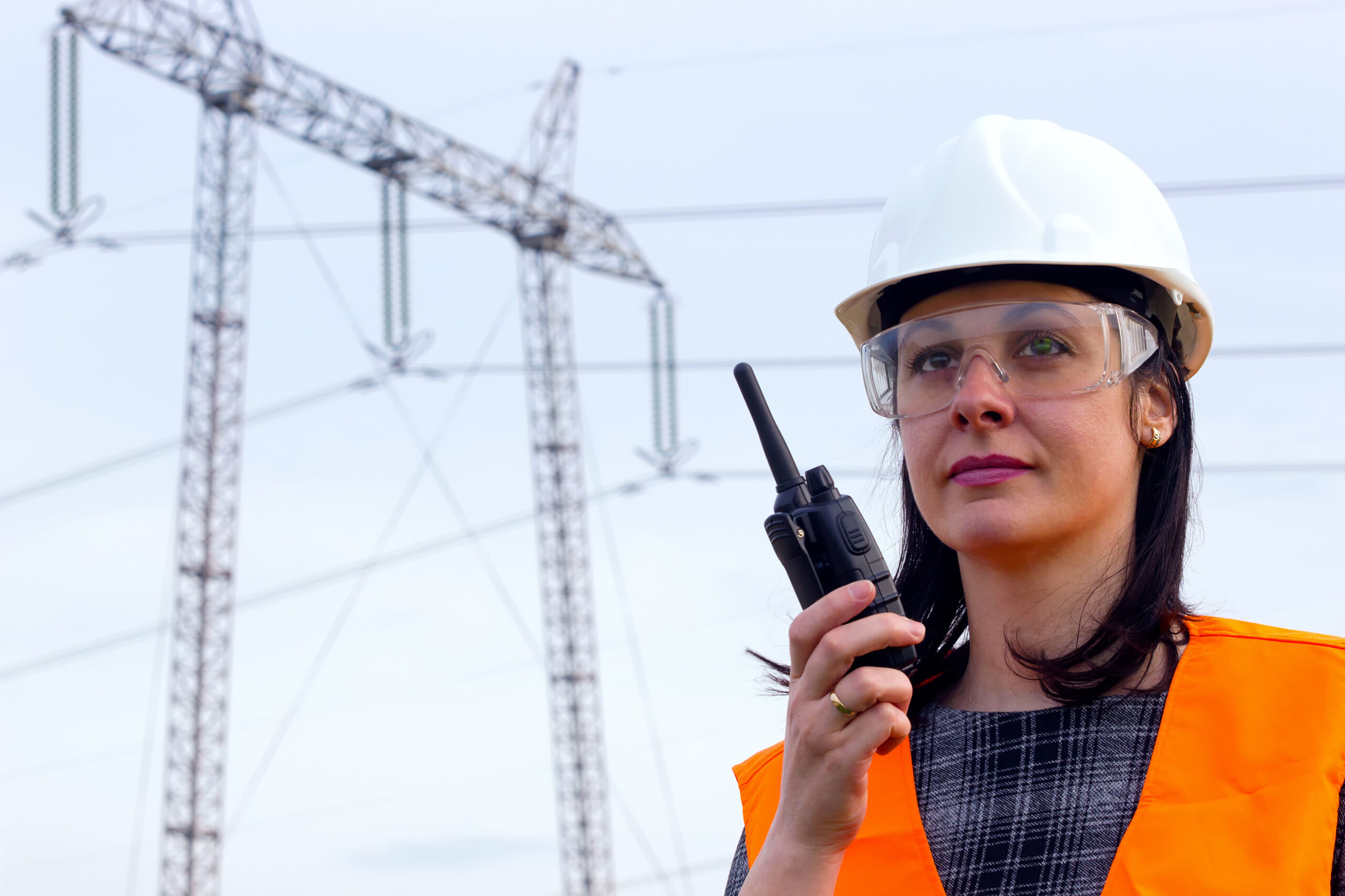 A female electrical contractor talking on a walkie- talkie