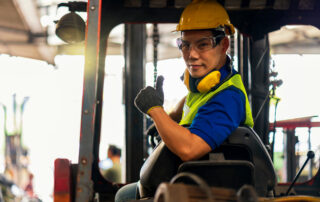 A male Engineer or technician driving a forklift. The driver is wearing eye protection to help prevent eye injuries.