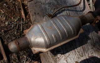A Catalytic Converter, removed from a vehicle sitting on the ground.