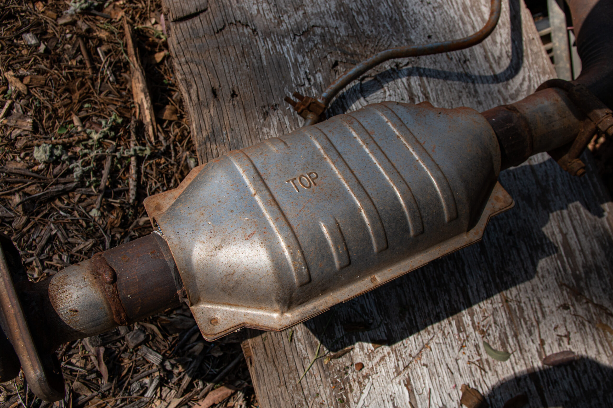 A Catalytic Converter, removed from a vehicle sitting on the ground.