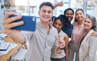 15 Low- and No-cost Employee Benefits to Offer: A group of employees taking a selfie after a meeting. One way to retain top talent is to offer extra benefits.