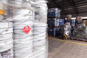 Waste barrels with hazard warning symbol in the warehouse. The flammable liquid is stored properly in this facility.