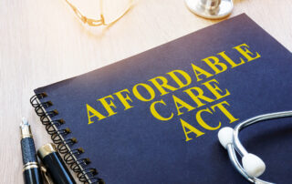 A blue medical journal with Affordable Care Act (ACA) in yellow. A stethoscope sits on top of the journal