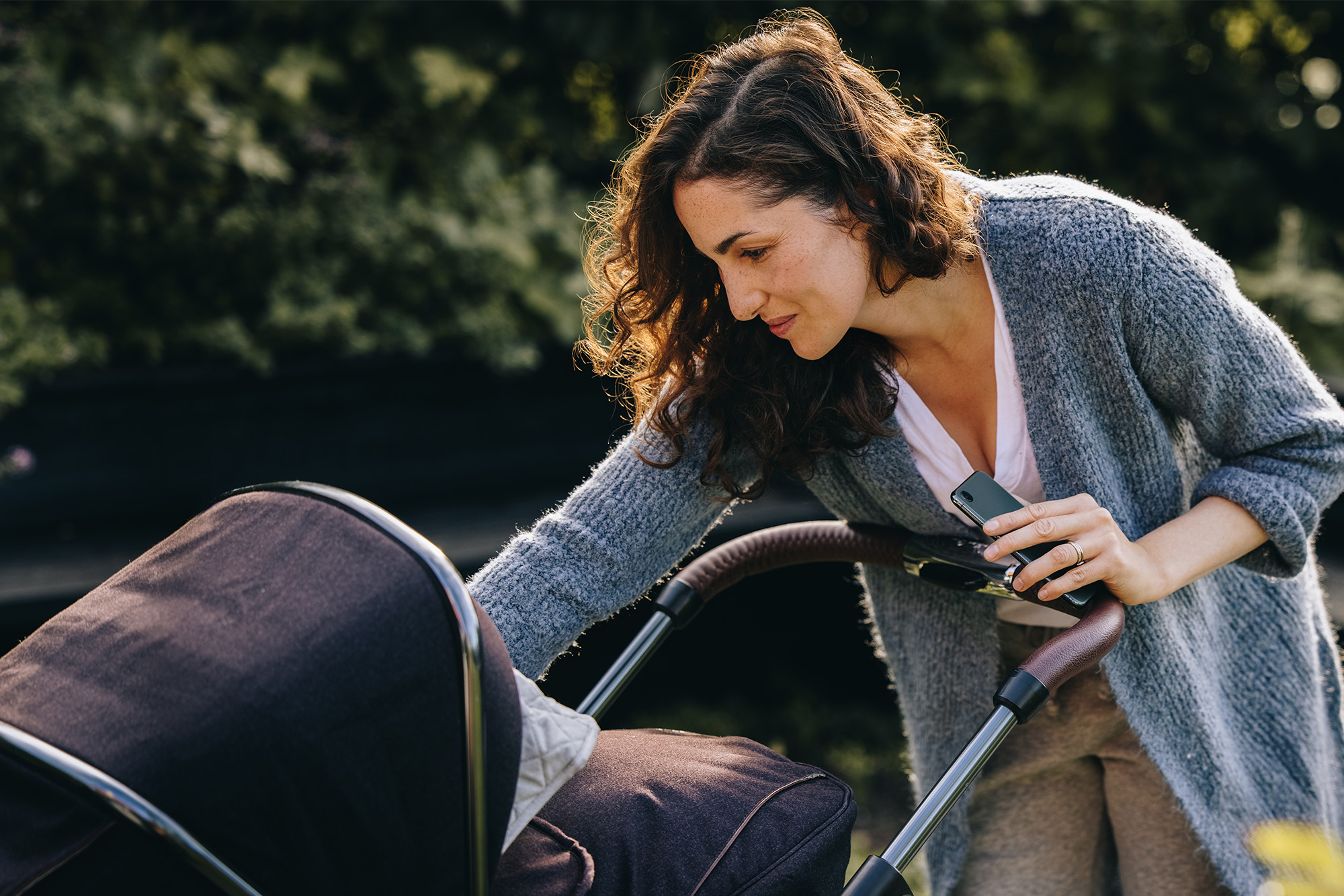 Woman with her baby in stroller outdoors.