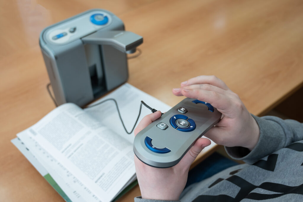 A visually impaired man uses a scanning and reading machine