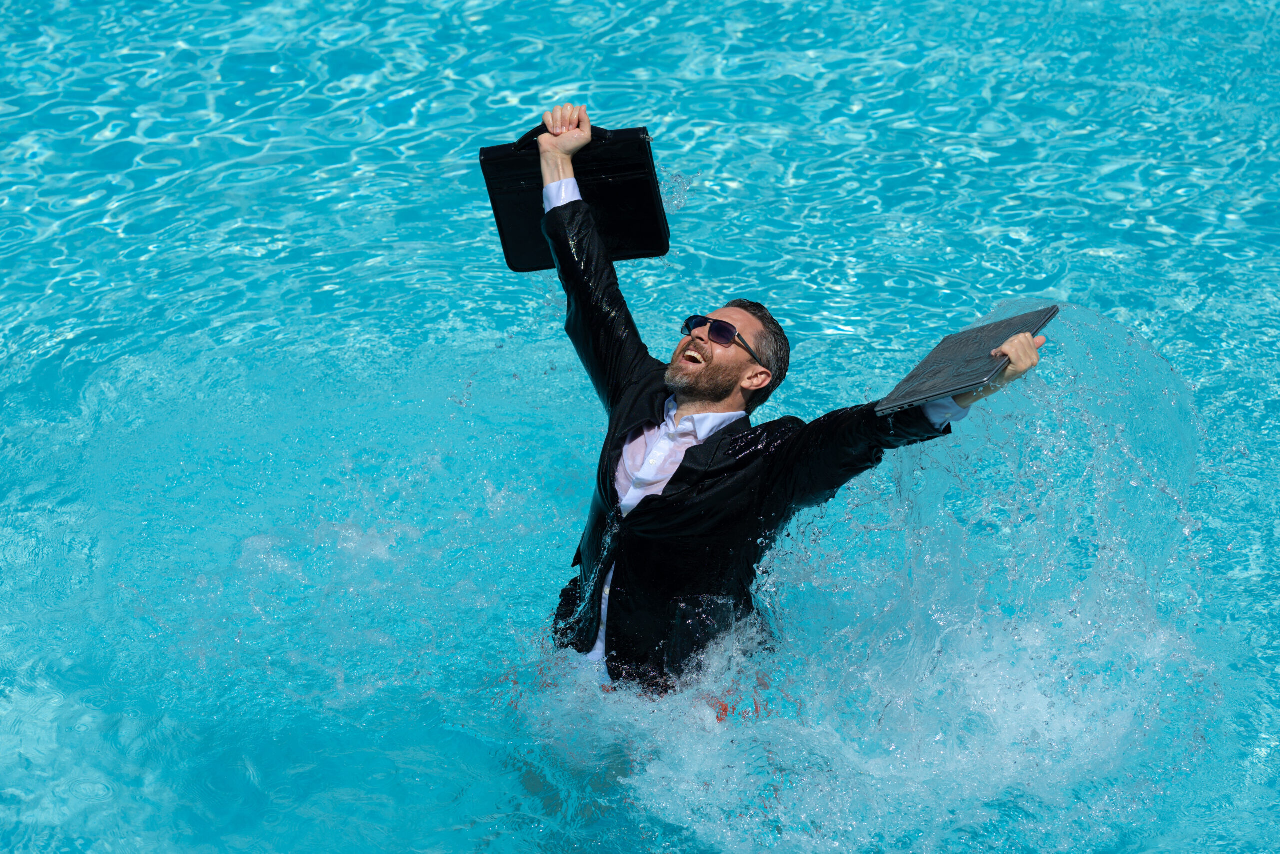 Four Strategies Radically Transforming Employee Well-Being: businessman in wet suit excited jumping in swim pool.