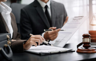 Controversial Bills Target Employer Obligations: two colleagues sitting at a table reviewing legal documents.