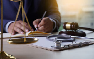 Medical Malpractice Is the Most Severe Loss in Senior Care Facilities: A doctor sitting at a table with a gavel, stethoscope in the foreground.
