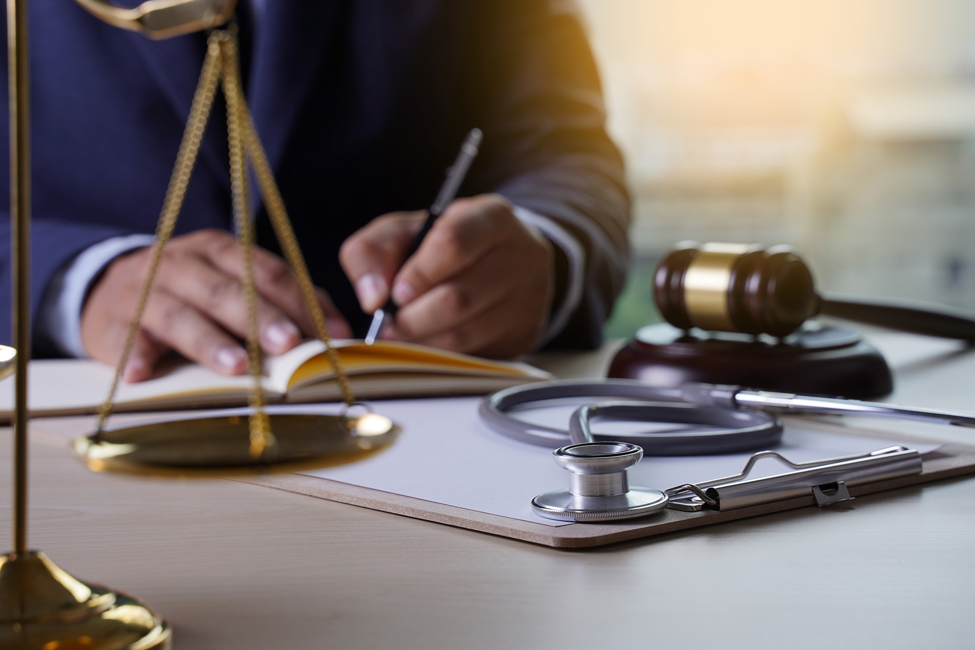 Medical Malpractice Is the Most Severe Loss in Senior Care Facilities: A doctor sitting at a table with a gavel, stethoscope in the foreground.