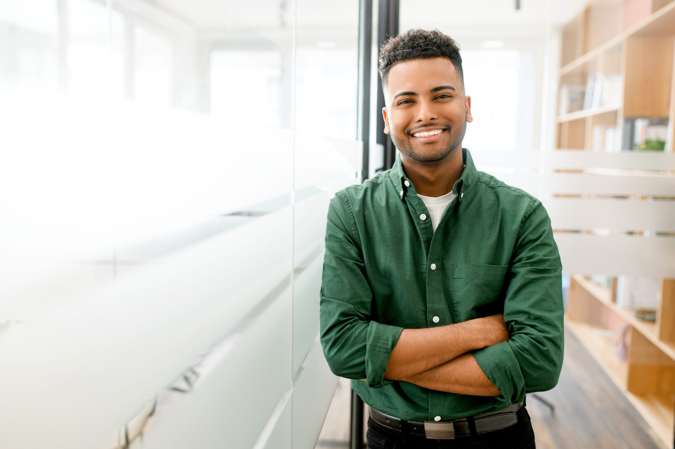 Educating Young Employees on Open Enrollment: Portrait of cheerful young man wearing smart casual shirt in modern coworking space