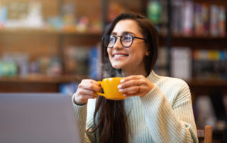 6 Ways to Capture Employees’ Attention at Open Enrollment: lady enjoying coffee during work on laptop computer.