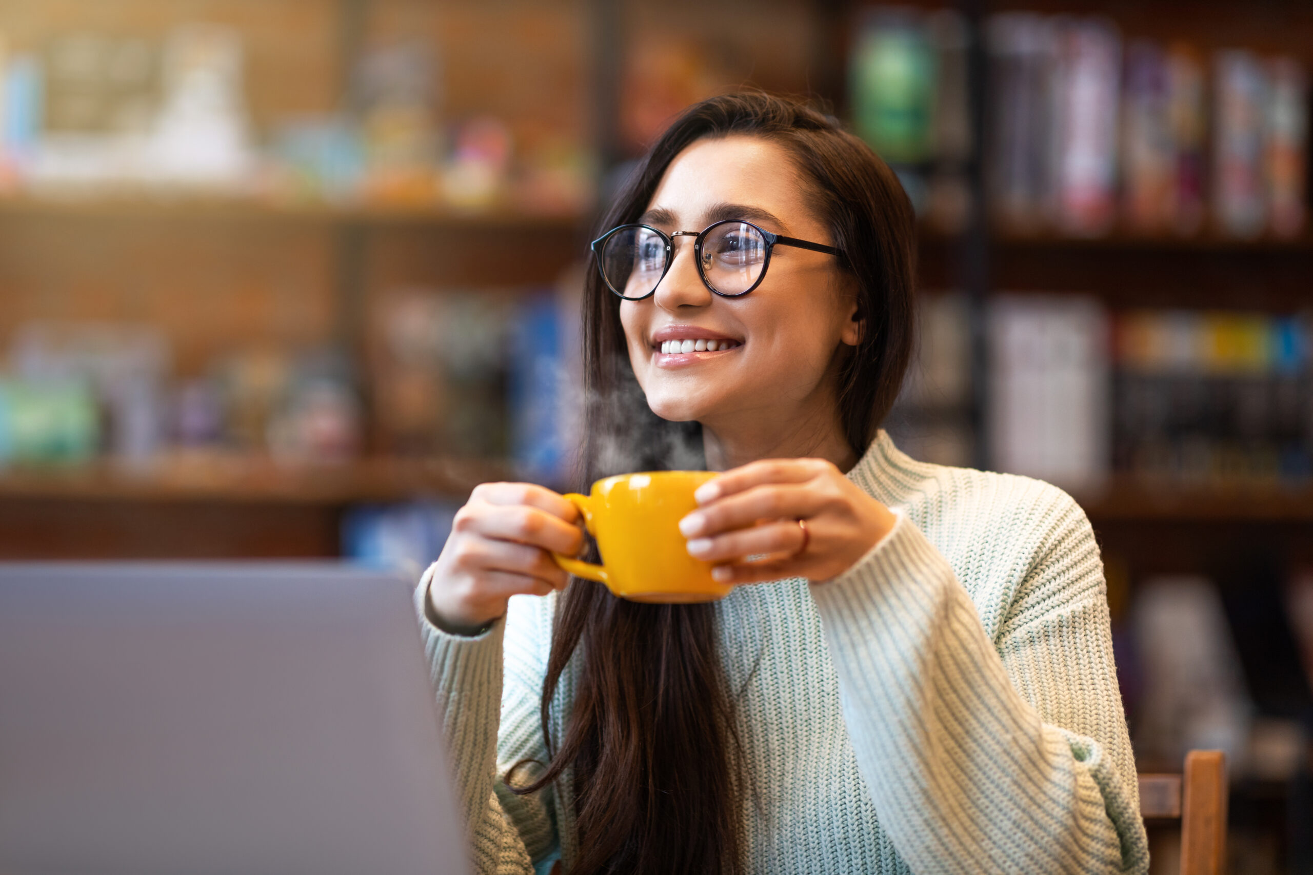 6 Ways to Capture Employees’ Attention at Open Enrollment: lady enjoying coffee during work on laptop computer.