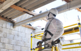 Safety Matters: Asbestos Awareness: A construction worker in a hazmat suit disposing of asbestos in an old warehouse.