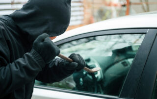 2023 Top Auto Hazards: A thief breaking into a car with a crowbar.