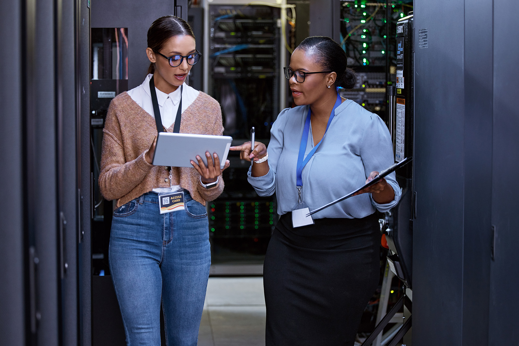 Importance of Privacy and Cybersecurity: Two female IT professionals working in a server room.