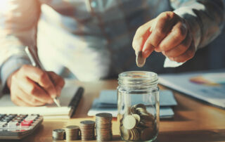 On-demand pay: a man counting coins while going over his bills