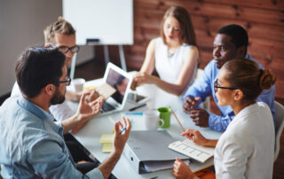 PPACA: A group of diverse colleagues sitting around a table.