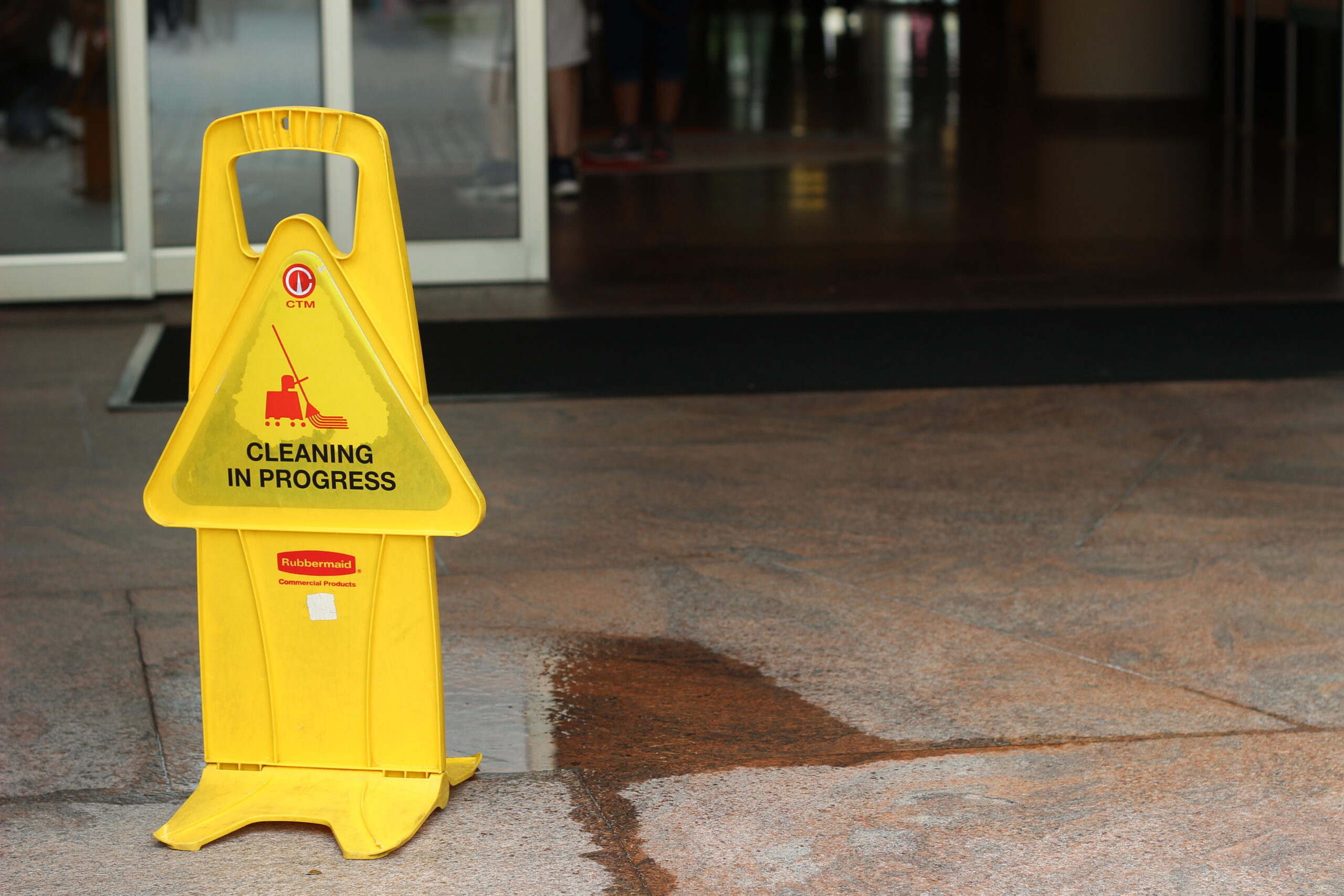 A wet floor sign outside of a building entrance.