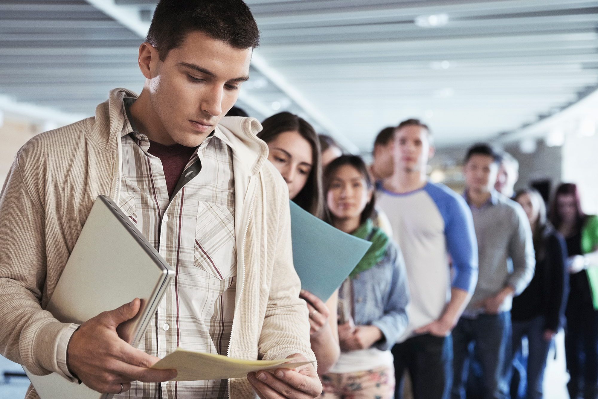 Support Your Staff as They Transition Back to Student Loan Payments: A line of young colleagues looking worried.