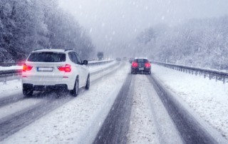 Winter Driving safety Tips: Two cars travelling the same direction on a snow-covered road.