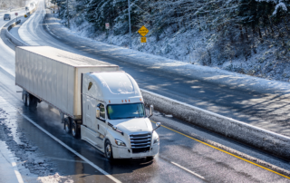 Winter Driving Tips for Truckers: An 18-wheeler driving on a snow-covered road.