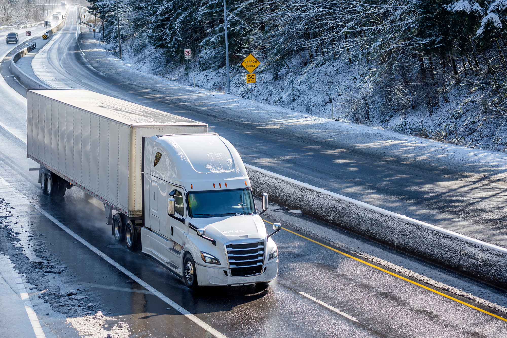 Winter Driving Tips for Truckers: An 18-wheeler driving on a snow-covered road.