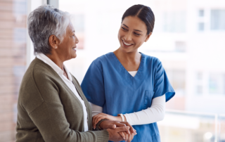 Supporting Caregivers in the Workplace: A female nurse engaging with an older female patient.