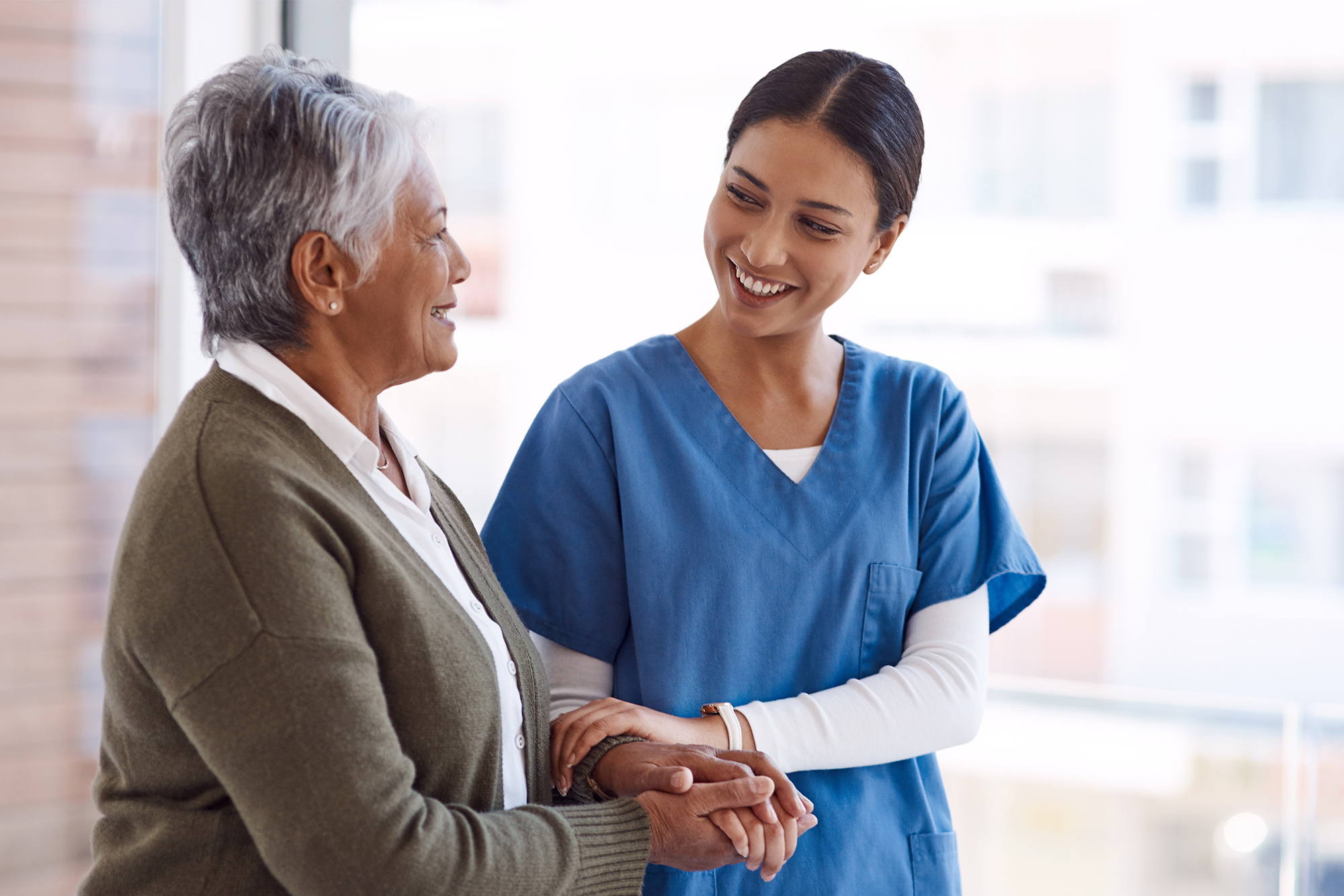 Supporting Caregivers in the Workplace: A female nurse engaging with an older female patient.