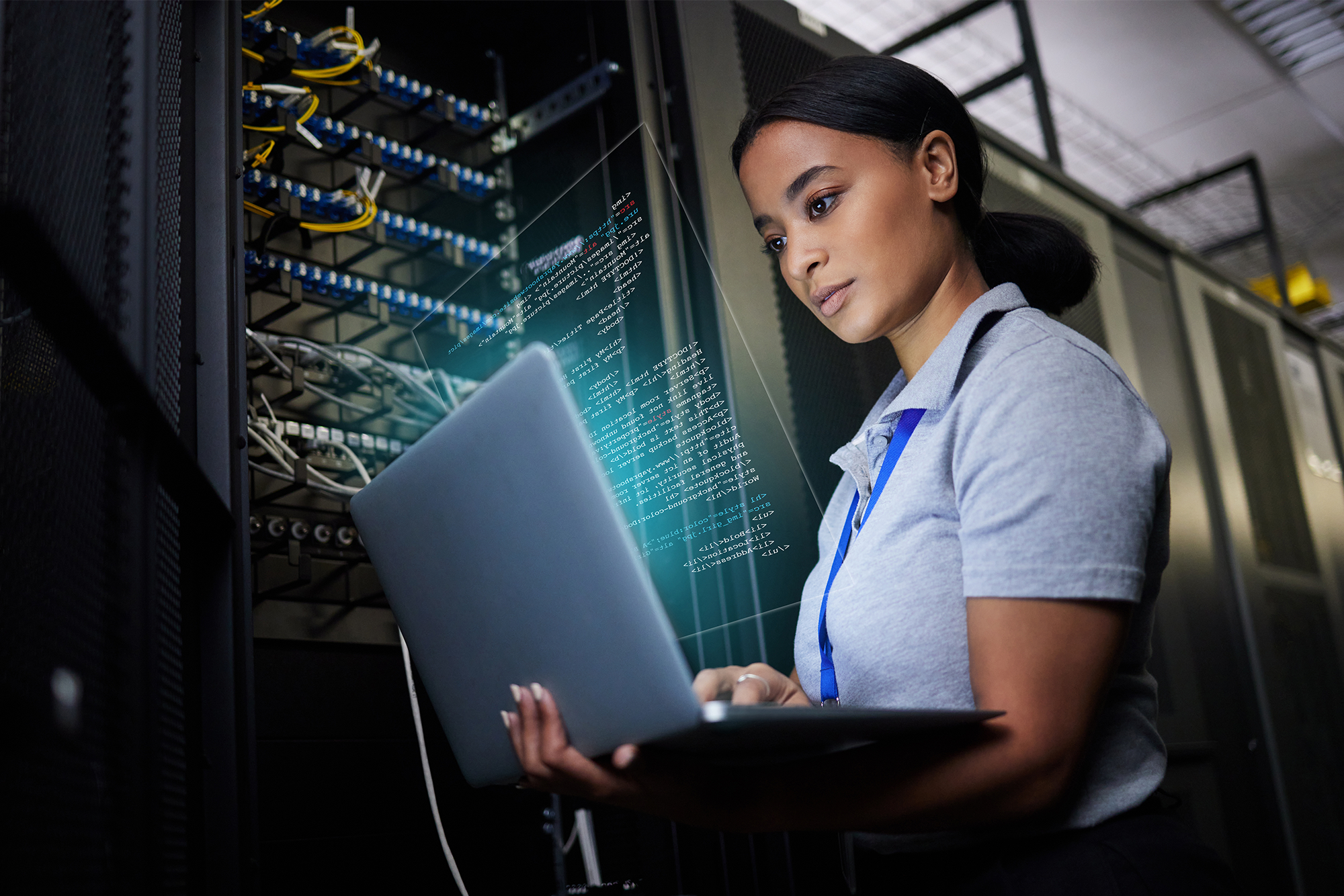 10 Essential Cybersecurity Controls: A young female IT professional logging in to a server with her laptop.
