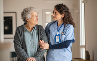 Best Practices for Patient Safety in Healthcare Facilities: A female nurse escorting an elderly patient in a hospital.