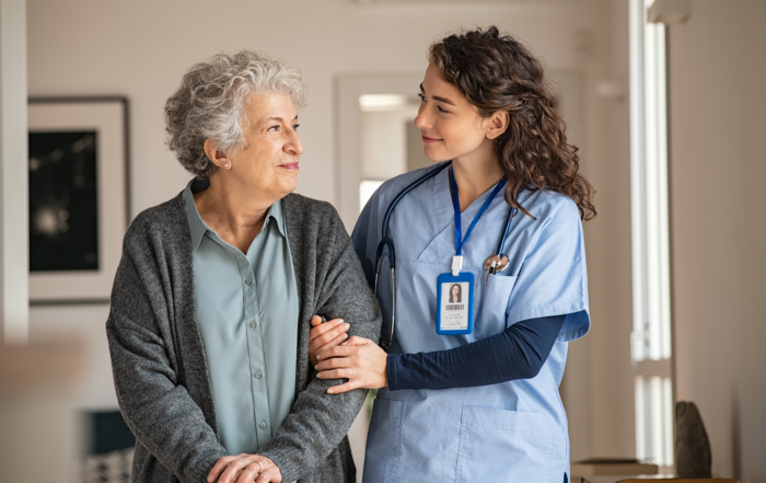 Best Practices for Patient Safety in Healthcare Facilities: A female nurse escorting an elderly patient in a hospital.