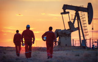 Oil and Gas Industry Coverage Options: A group of three oilfield workers walking towards an oil rig.