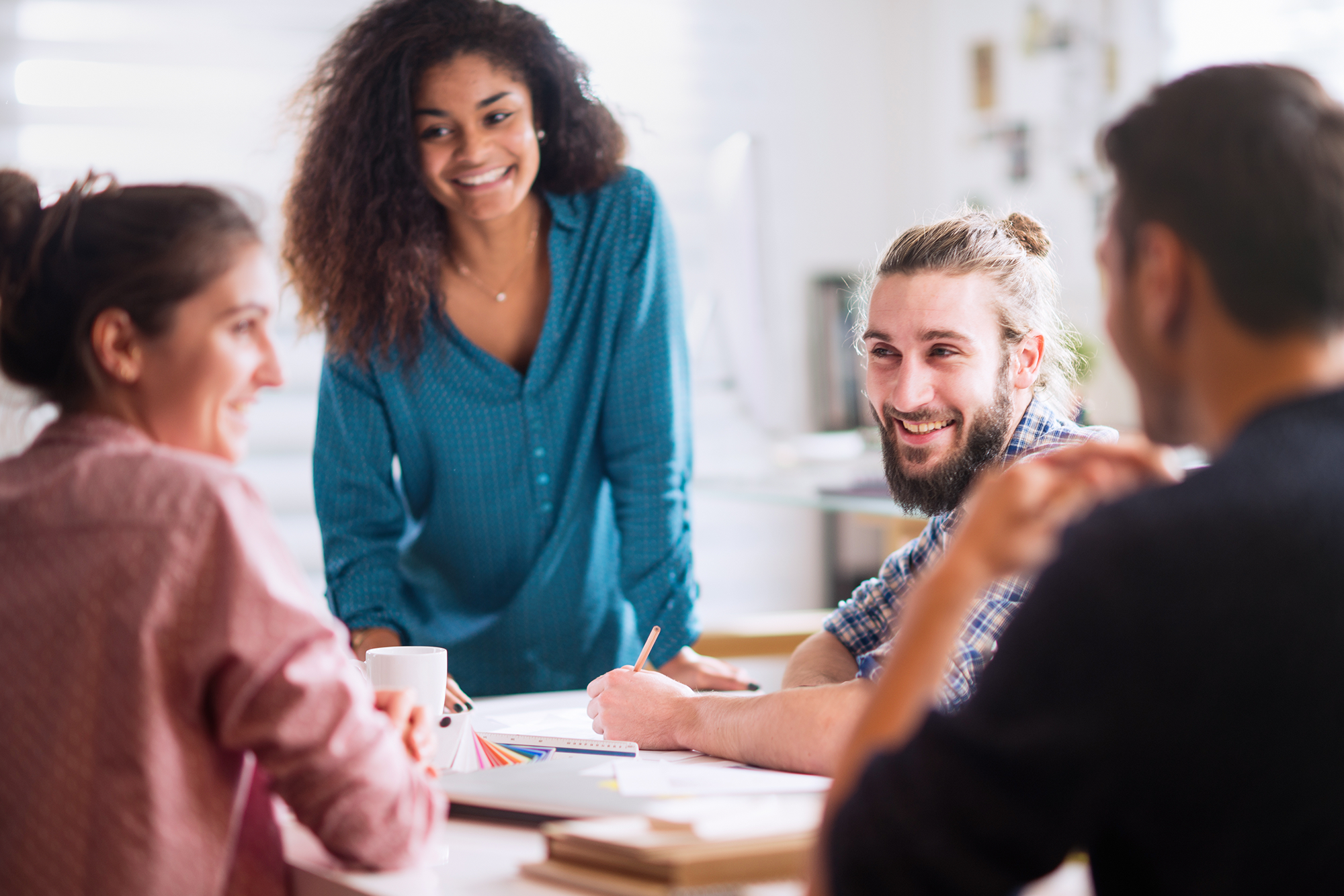 Tailoring Benefits to Boost Employee Retention: A group of diverse young colleagues in a meeting.