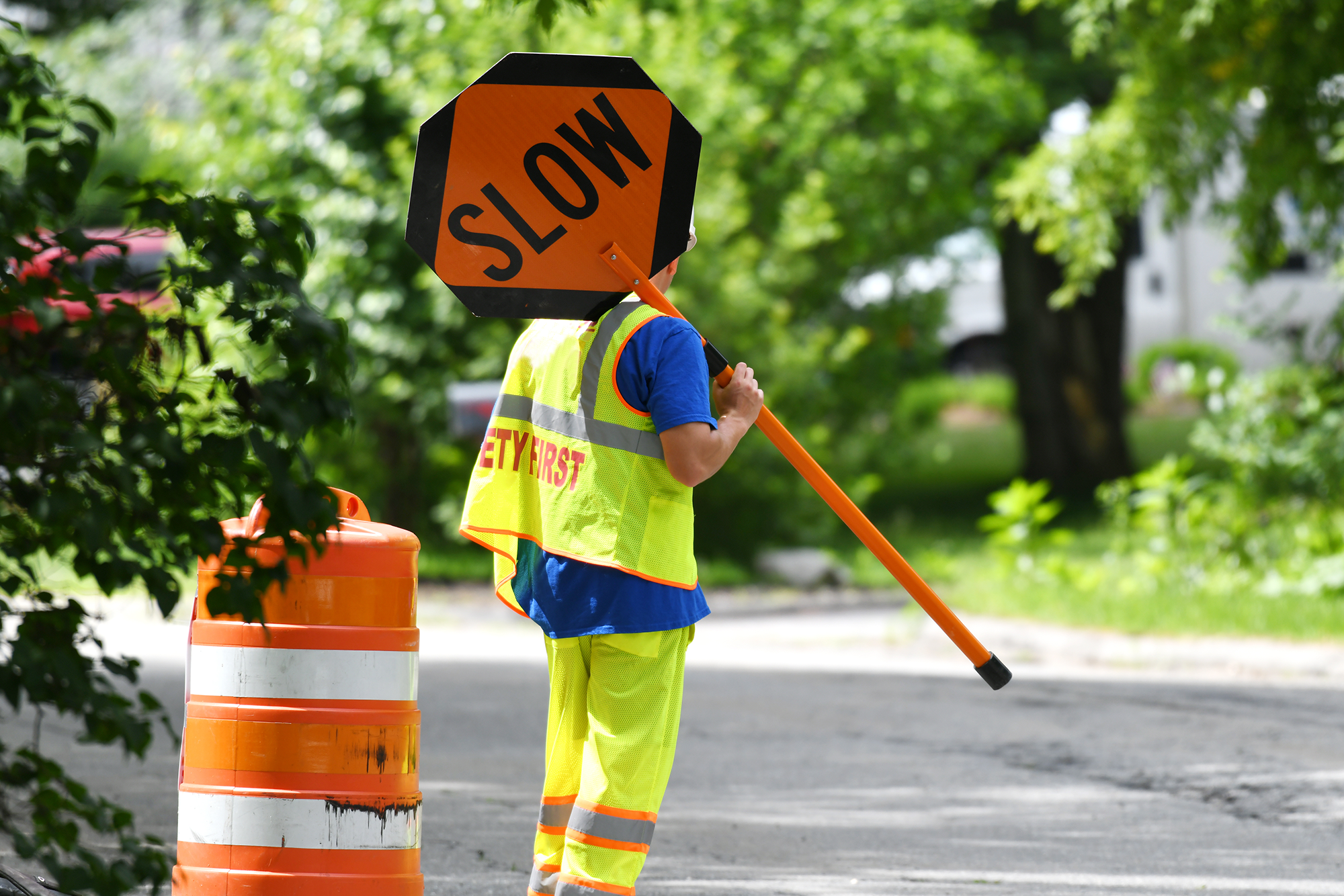 National Work Zone Awareness Week Takes Place April 15-19: A construction worker holding a slow sign in a construction work zone.