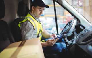 Steps for Businesses to Create Safer Drivers: A male driver sitting in his commercial vehicle going over a safety checklist.