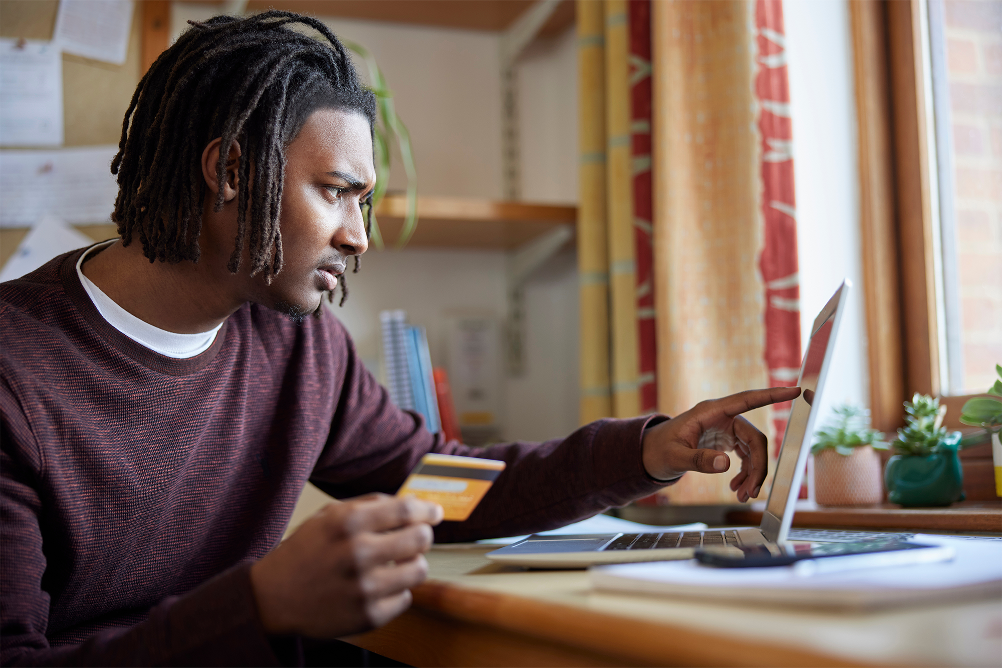 The Game-Changing Benefit You’ve Been Overlooking: SECURE 2.0’s Student Loan Matching - A young male making a student loan payment on his laptop,