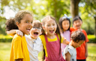 Multi-ethnic group of school children laughing and embracing