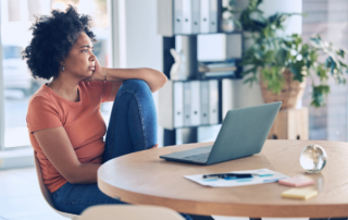 Anxiety Now Top Employee Mental Health Issue: A female sitting by her laptop with a stressful look on her face.