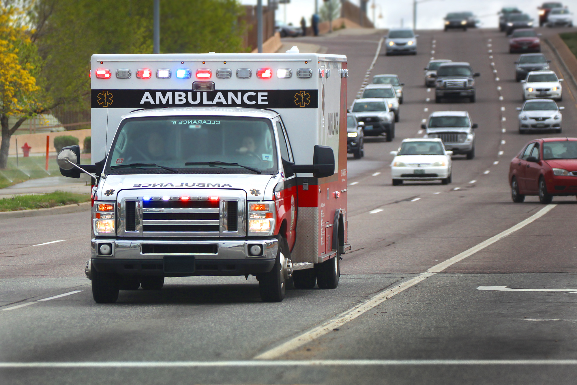 Give Employees Peace of Mind with Accident Coverage: An ambulace travelling on the highway with its lights flashing.