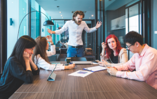 Preventing and Dealing With Workplace Violence: A manager yelling at colleagues in a business meeting.