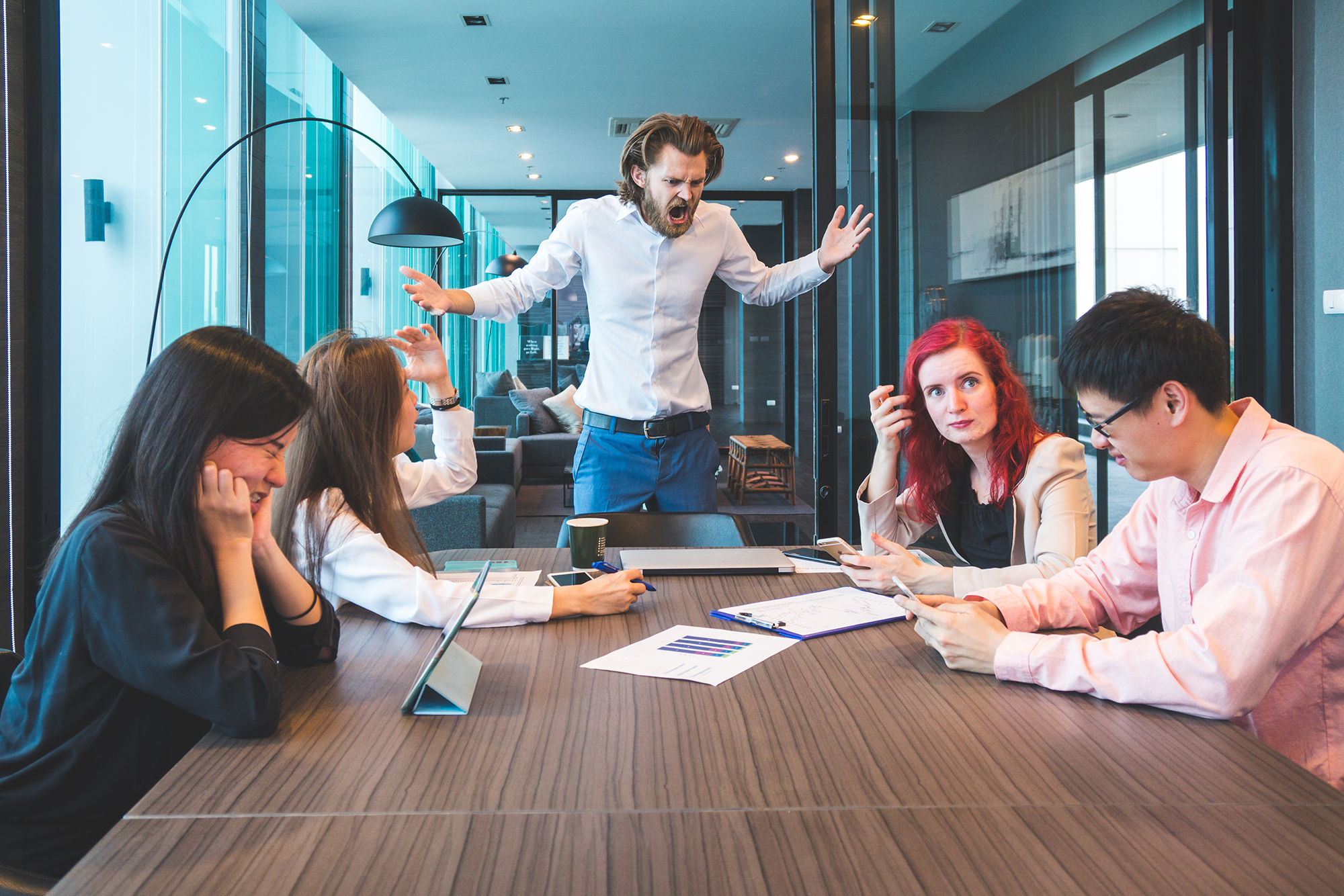 Preventing and Dealing With Workplace Violence: A manager yelling at colleagues in a business meeting.