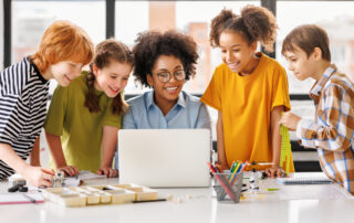 Teacher and students at the her computer.