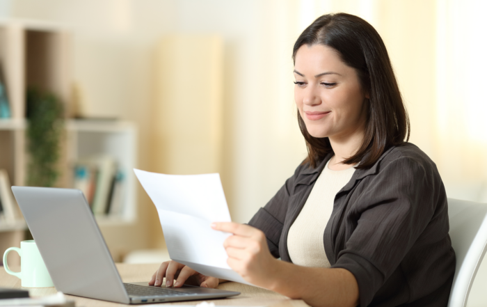 2025 Open Enrollment: A woman reviewing her open enrollment paperwork.