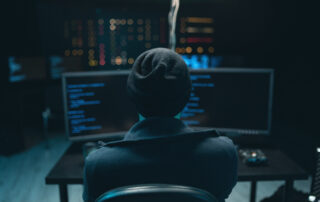 Dangerous Hooded Hacker Breaks into Government Data Servers and Infects Their System with a Virus. Hideout Place has Dark Atmosphere. Wanted programmer coding virus ransomware using computers.