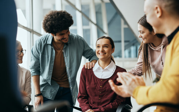 Young happy woman receives support from attenders of group therapy at mental health center.