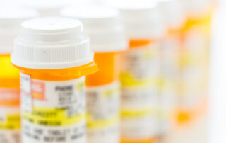 Prescription pills in yellow bottles on a white background.